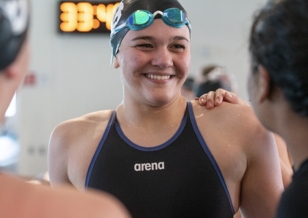 Smiling with her team, sophomore Sofia Ellison celebrates after she and her teammates won April 8 at the SM Aquatic Center. Her relay team broke the school’s girl’s 200 Yard Freestyle Relay record. They eclipsed the record by only 0.1 seconds. “I’m really proud of my teammates,” Ellison said. “It’s been a goal for us all season long [to beat the record].” photo by Kara Simpson